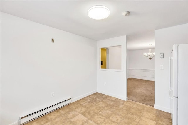 spare room featuring light colored carpet, a chandelier, and a baseboard heating unit