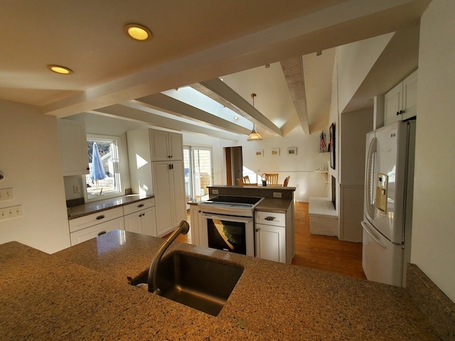 kitchen with white refrigerator with ice dispenser, white cabinets, sink, beam ceiling, and wood-type flooring