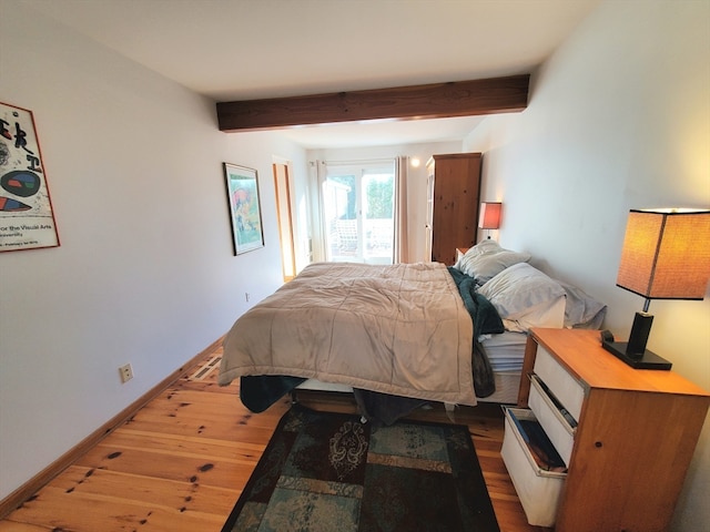 bedroom featuring beamed ceiling and hardwood / wood-style flooring