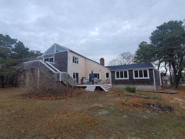 back of property featuring a lawn and a wooden deck