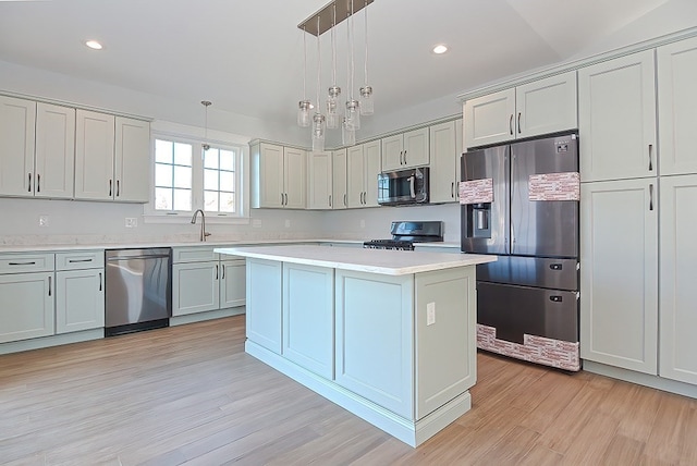 kitchen with a center island, appliances with stainless steel finishes, pendant lighting, and light hardwood / wood-style flooring