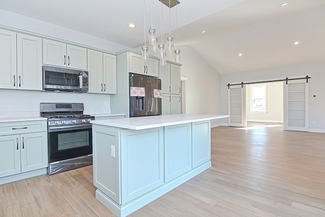 kitchen featuring lofted ceiling, a center island, a barn door, stainless steel appliances, and light hardwood / wood-style floors