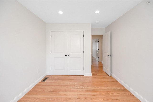 unfurnished bedroom with light hardwood / wood-style floors and a closet