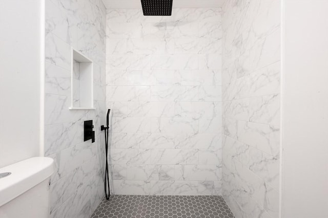 bathroom with tiled shower and toilet