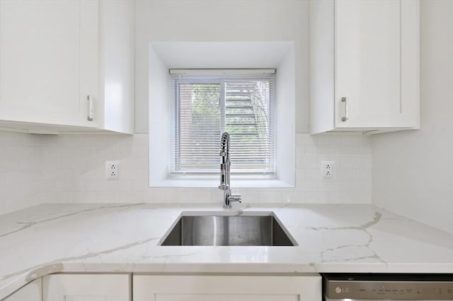 kitchen with light stone counters, sink, decorative backsplash, and white cabinets