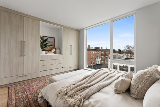 bedroom with hardwood / wood-style floors and expansive windows