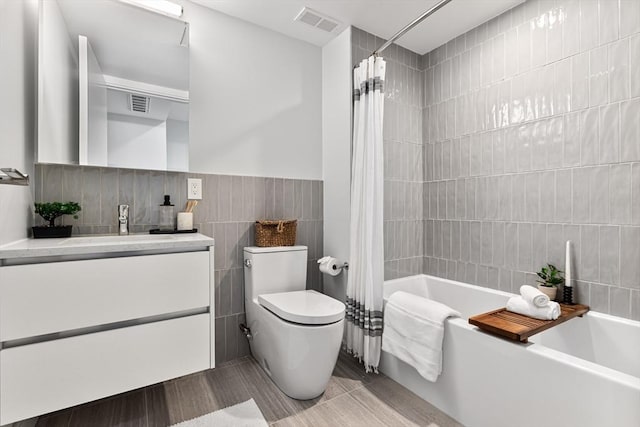 full bathroom featuring vanity, toilet, tile walls, and shower / tub combo with curtain