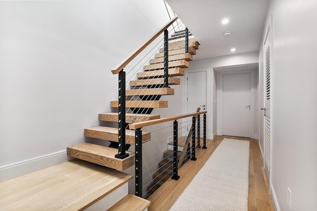 stairs featuring hardwood / wood-style floors