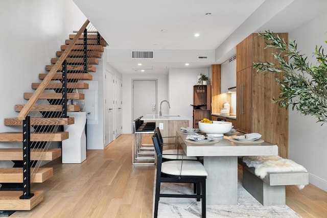 dining space with sink and light hardwood / wood-style flooring