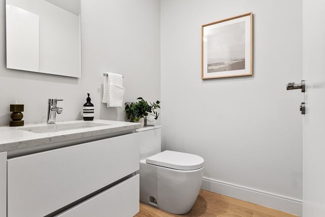 bathroom featuring hardwood / wood-style flooring, toilet, and vanity