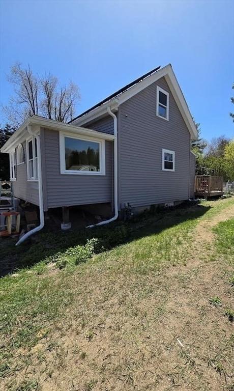 view of side of property featuring a yard and a deck