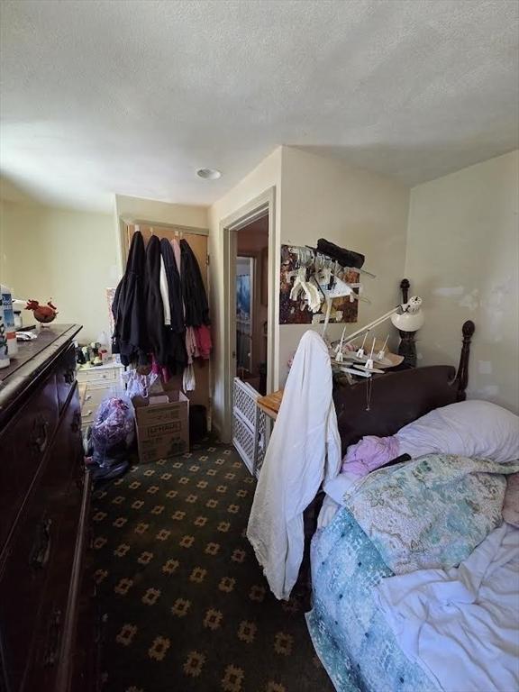 carpeted bedroom featuring a closet and a textured ceiling