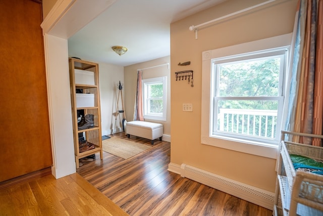 interior space with a baseboard heating unit and hardwood / wood-style flooring