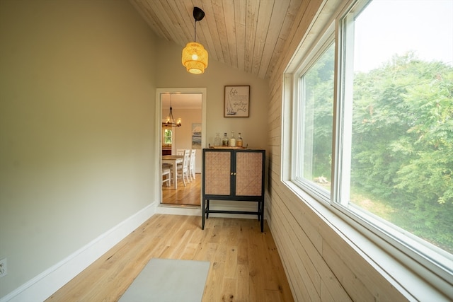 interior space with lofted ceiling, wooden ceiling, a notable chandelier, and light hardwood / wood-style flooring