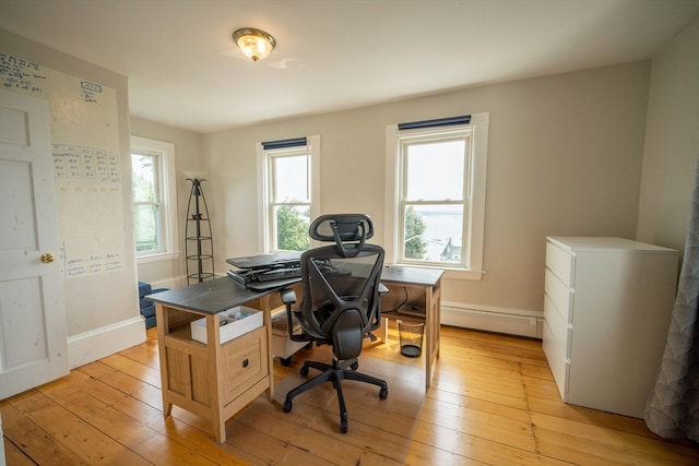 home office with baseboard heating and light hardwood / wood-style flooring