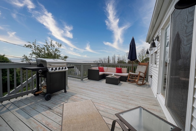 wooden deck with an outdoor hangout area and a grill