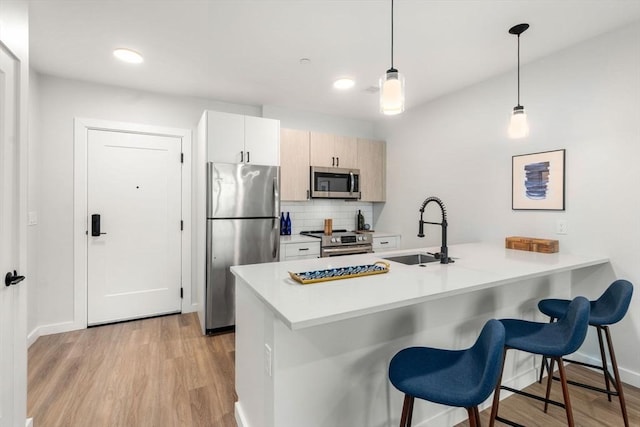 10 Somerset Unit 201, Winthrop, MA 02152 - kitchen with appliances with stainless steel finishes, a peninsula, light wood-type flooring, a breakfast bar, and recessed lighting