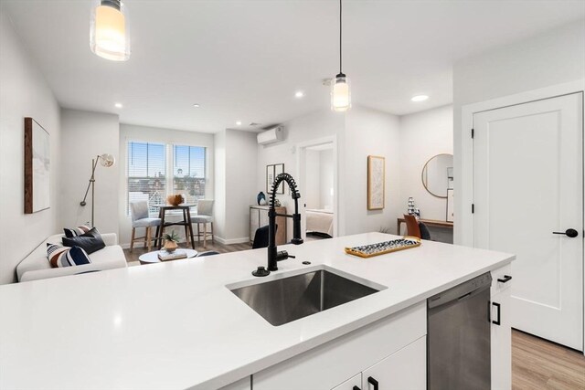 10 Somerset Unit 201, Winthrop, MA 02152 - kitchen with stainless steel dishwasher, light countertops, hanging light fixtures, light wood-style floors, and white cabinets