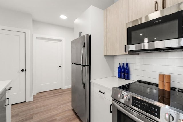 10 Somerset Unit 201, Winthrop, MA 02152 - kitchen with stainless steel appliances, backsplash, light countertops, light wood-type flooring, and modern cabinets