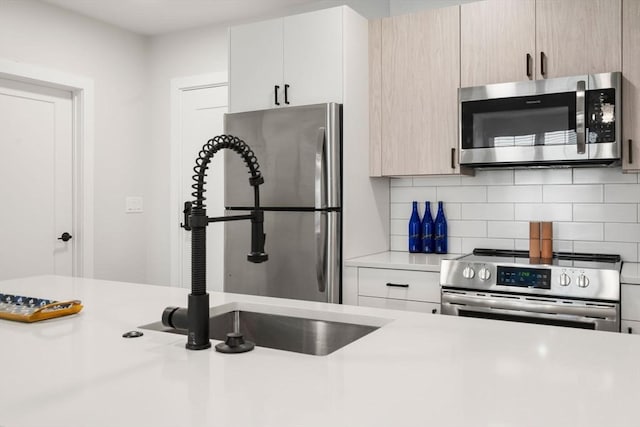 10 Somerset Unit 201, Winthrop, MA 02152 - kitchen featuring appliances with stainless steel finishes, light countertops, and decorative backsplash