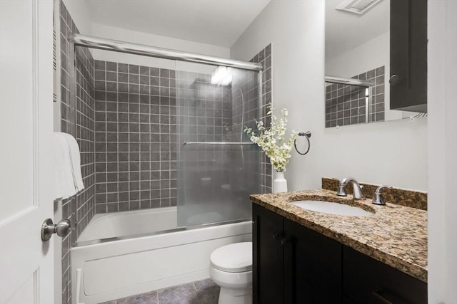bathroom with combined bath / shower with glass door, vanity, and toilet