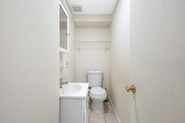 bathroom with tile patterned flooring, vanity, and toilet