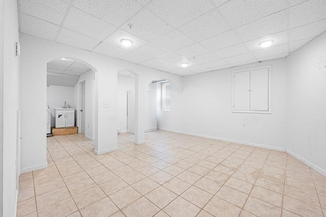 spare room with sink, a drop ceiling, and light tile patterned floors