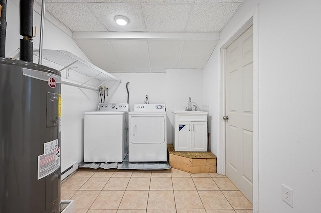 clothes washing area featuring separate washer and dryer, baseboard heating, light tile patterned floors, water heater, and sink