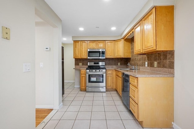 kitchen featuring sink, backsplash, appliances with stainless steel finishes, light tile patterned flooring, and light brown cabinets