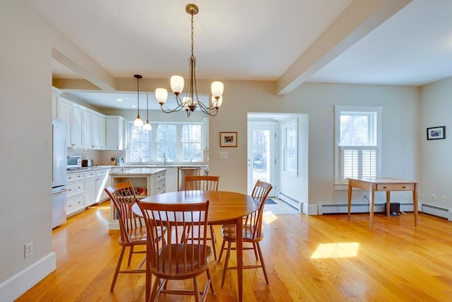 dining area featuring light wood-type flooring, a baseboard radiator, plenty of natural light, and beamed ceiling