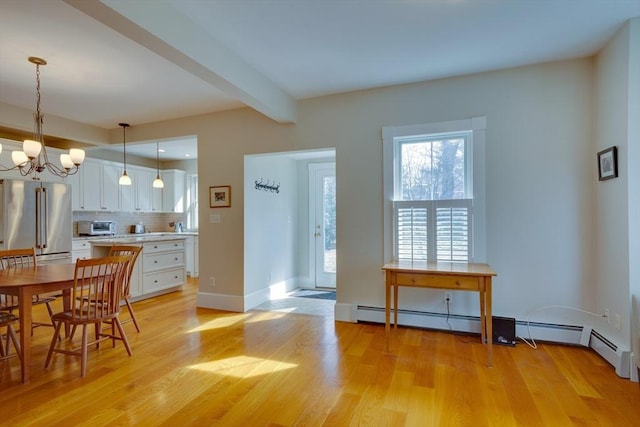 dining room with baseboards, a toaster, beamed ceiling, light wood-type flooring, and a chandelier