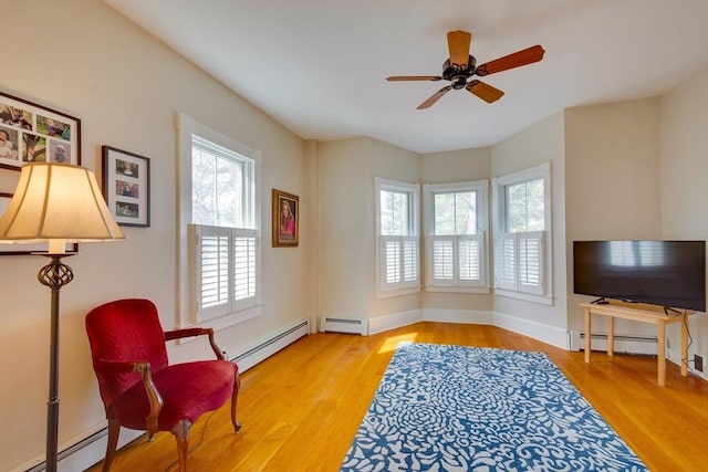 living area with a baseboard heating unit and wood finished floors