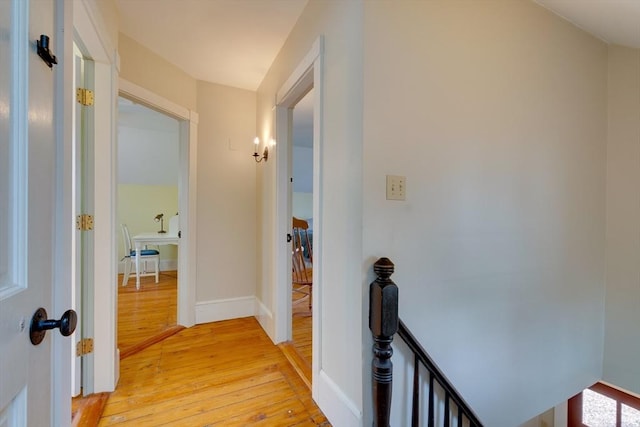 hall with baseboards and light wood finished floors