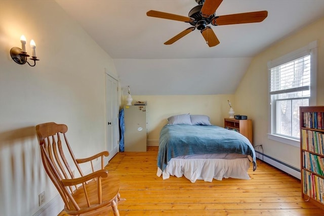 bedroom featuring vaulted ceiling, baseboard heating, ceiling fan, and hardwood / wood-style floors