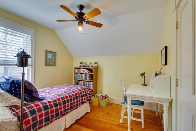 bedroom featuring baseboards, a ceiling fan, lofted ceiling, and light wood-style floors