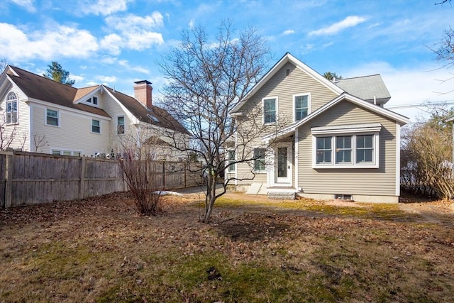 rear view of house with entry steps and fence