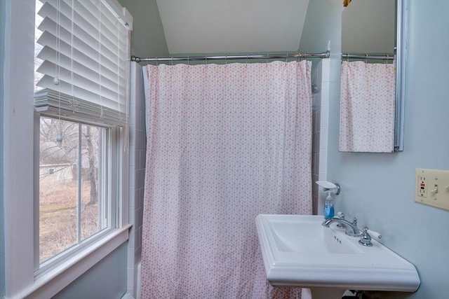 full bath featuring a shower with shower curtain and a sink