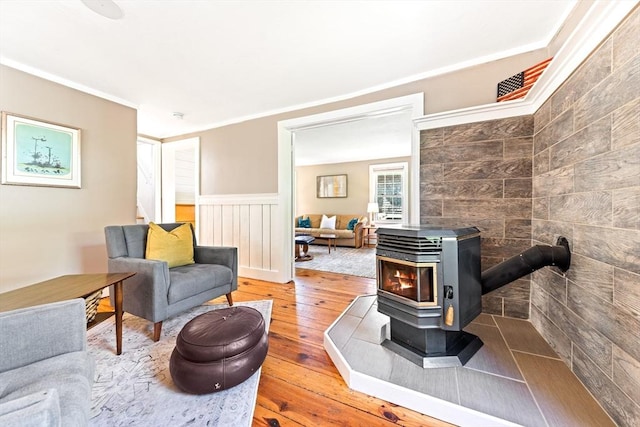 17 S High St, Ashburnham, MA 01430 - living room featuring hardwood / wood-style flooring, a wood stove, a wainscoted wall, stairway, and ornamental molding