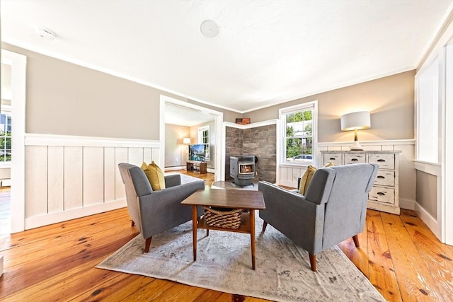 17 S High St, Ashburnham, MA 01430 - living area with a wood stove, a wainscoted wall, light wood-type flooring, and ornamental molding