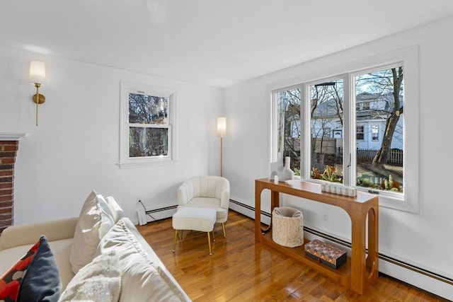 sitting room featuring hardwood / wood-style floors and a baseboard heating unit