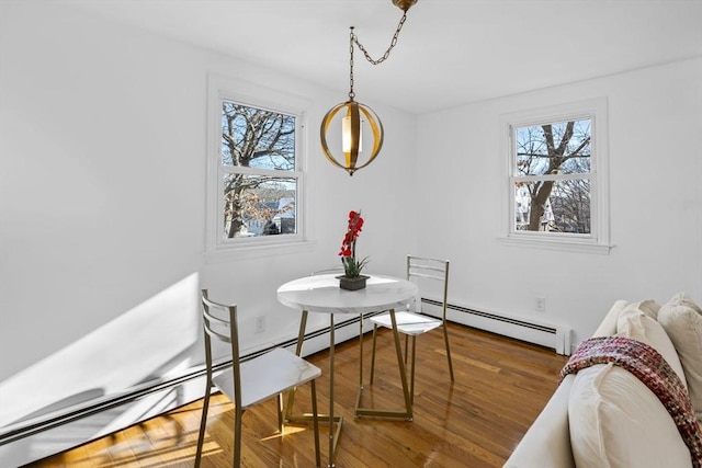 dining area with plenty of natural light, hardwood / wood-style floors, and a baseboard heating unit