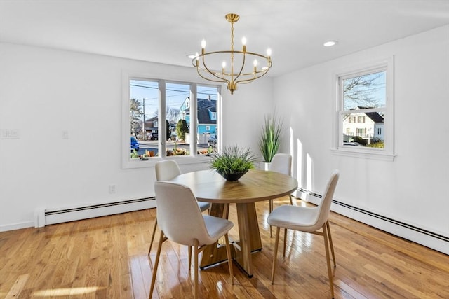 dining room featuring a chandelier, light wood-type flooring, and baseboard heating