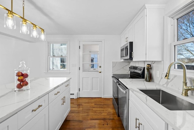 kitchen with light stone countertops, sink, tasteful backsplash, white cabinets, and appliances with stainless steel finishes