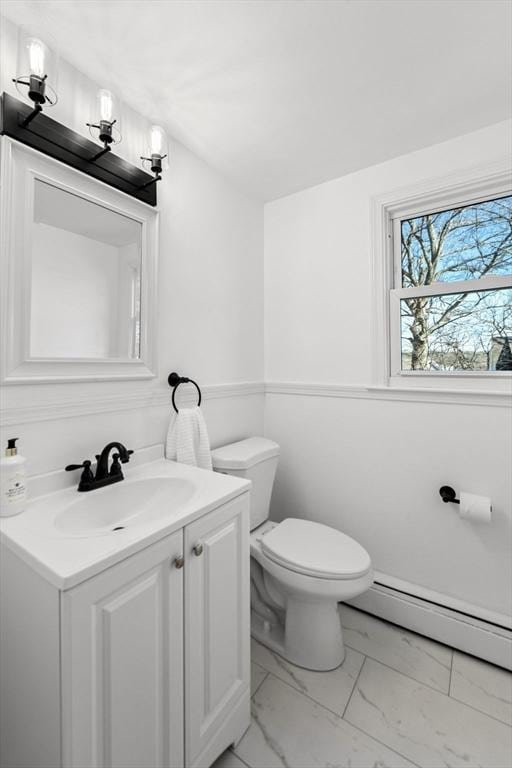 bathroom featuring baseboard heating, vanity, and toilet