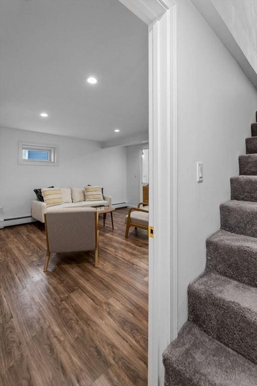 stairs with wood-type flooring and a baseboard radiator