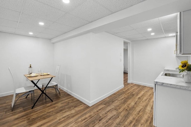 dining space featuring a paneled ceiling, dark hardwood / wood-style floors, and sink