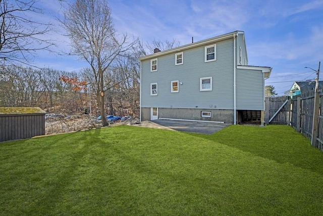 rear view of house featuring a lawn and a patio