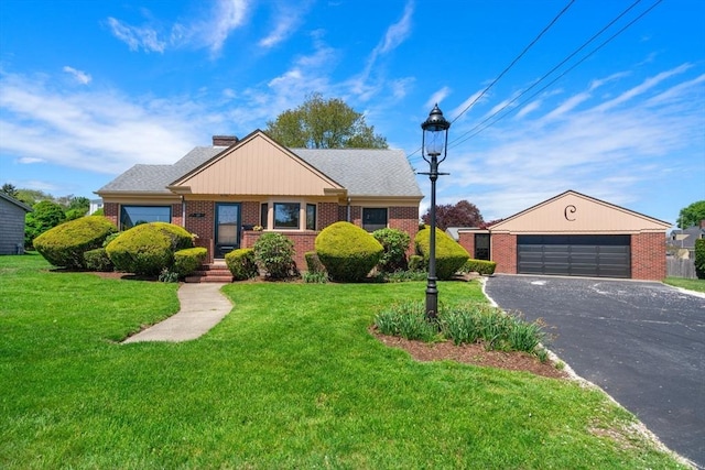 view of front facade with brick siding, a front lawn, asphalt driveway, and a chimney