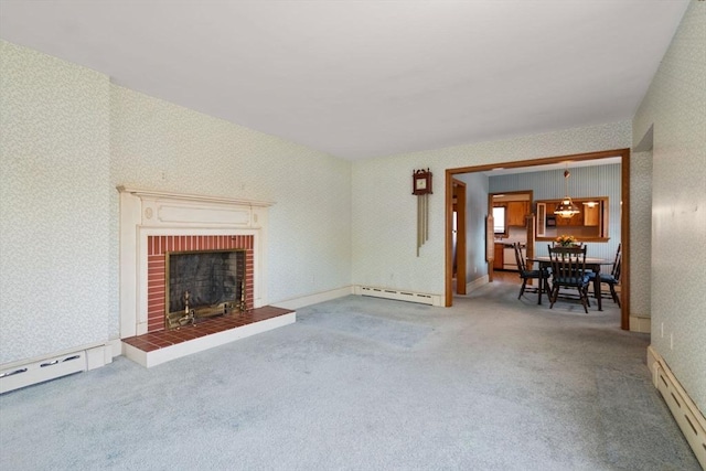 unfurnished living room with a baseboard radiator, wallpapered walls, carpet floors, and a fireplace
