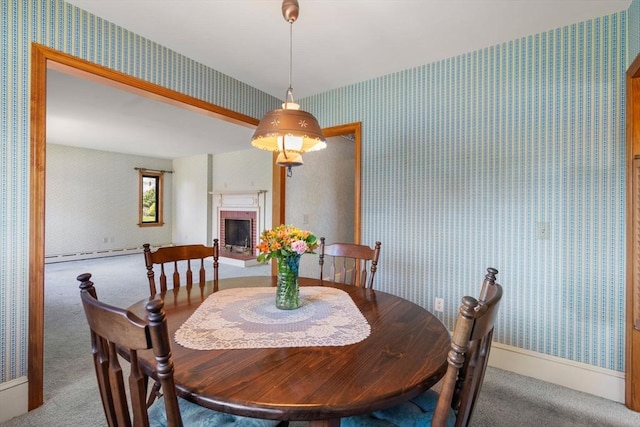 carpeted dining space with wallpapered walls, a brick fireplace, and a baseboard radiator